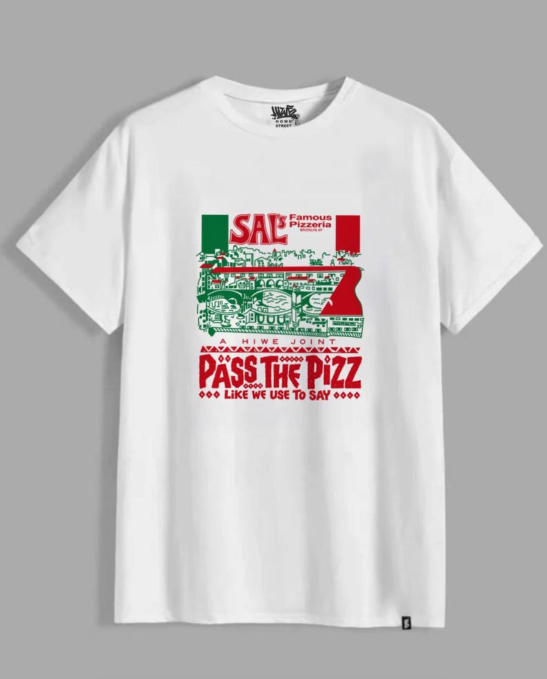 Puede incluir: Una camiseta blanca de manga corta con un estampado gr&aacute;fico que incluye el texto Sal's Famous Pizzeria Brooklyn, A Hiwe Joint y Pass The Pizz Like We Use To Say. El dise&ntilde;o presenta detalles en verde y rojo y una ilustraci&oacute;n.