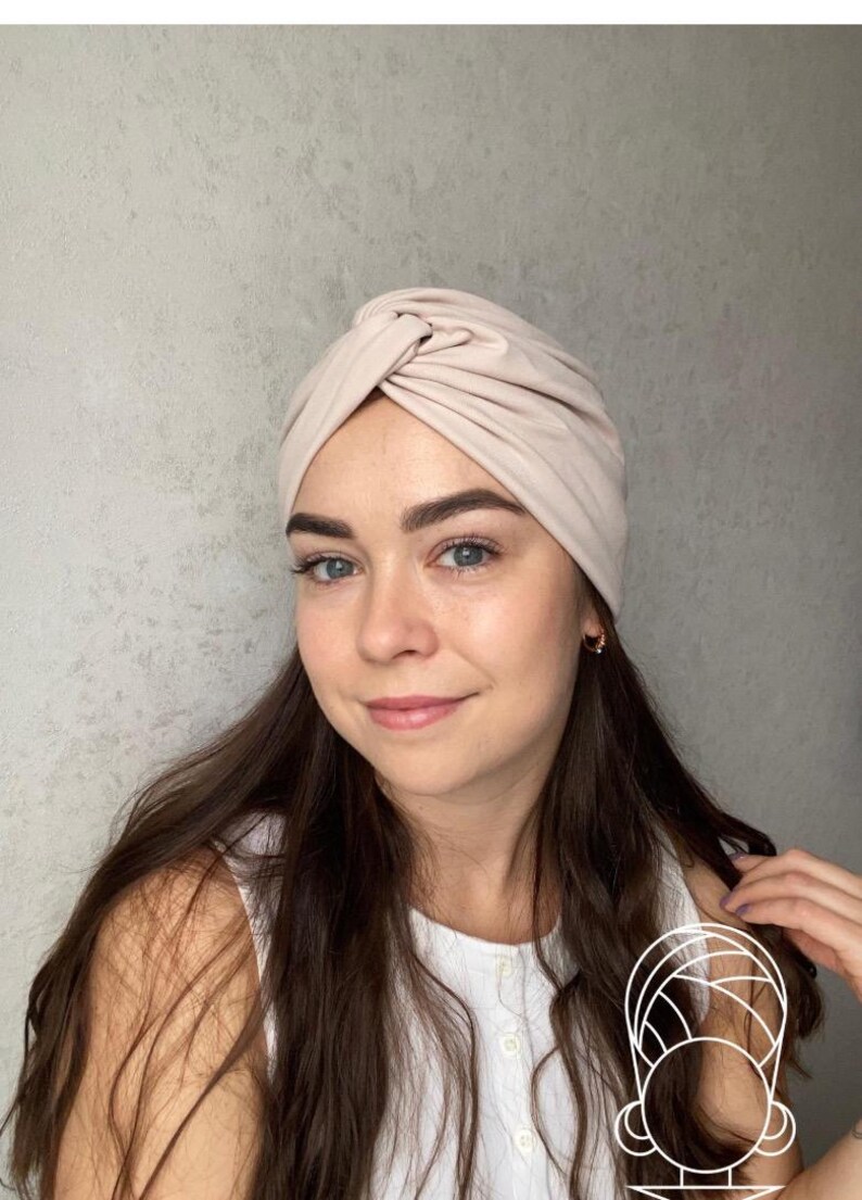 Pode incluir: Uma faixa de cabe&ccedil;a estilo turbante bege. O tecido &eacute; macio e franzido na parte superior, criando um design elegante e com n&oacute;s. Este acess&oacute;rio de cabe&ccedil;a &eacute; um acess&oacute;rio de moda para v&aacute;rias ocasi&otilde;es.