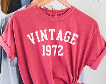 Könnte beinhalten: Ein T-Shirt in kirschrot mit dem Text "Vintage 1972" in Weiß.