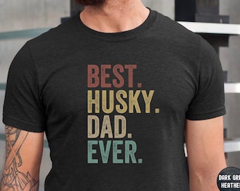 May include: Dark grey heather t-shirt with the text "BEST. HUSKY. DAD. EVER." in a vintage style font.