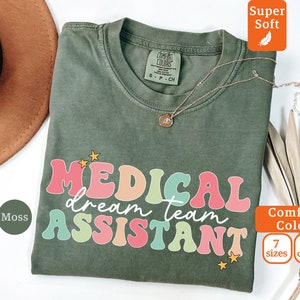 Op de afbeelding: Een groen T-shirt met de tekst "MEDICAL dream team ASSISTANT" in regenboogkleuren. Het shirt is gemaakt van een zachte, comfortabele stof en is verkrijgbaar in 7 maten en 10 kleuren.