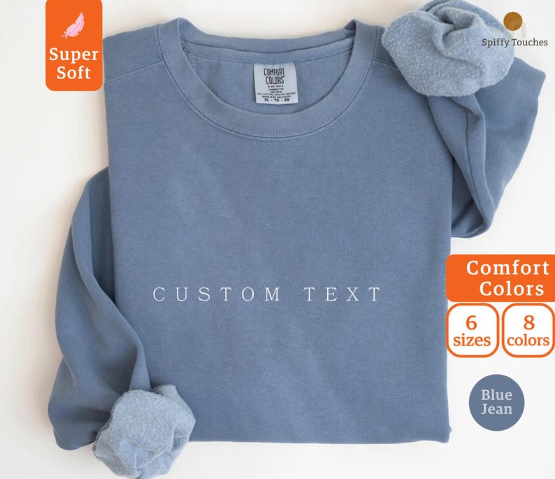May include: A blue jean sweatshirt with the text "CUSTOM TEXT" printed on the front. The sweatshirt is available in 6 sizes and 8 colors.