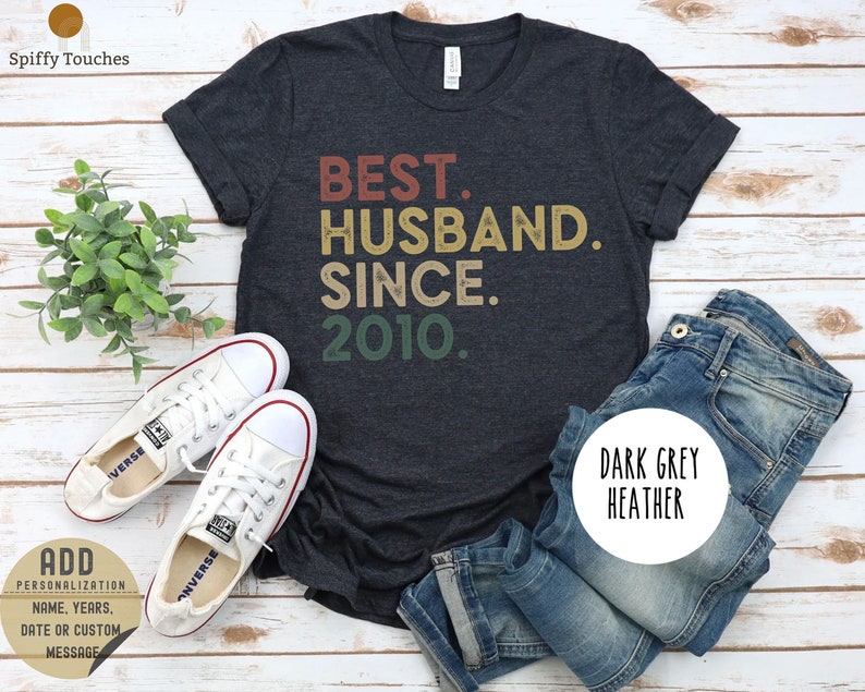 Puede incluir: Camiseta de color gris oscuro jaspeado con el texto "BEST. HUSBAND. SINCE. 2010." en una fuente de estilo vintage.