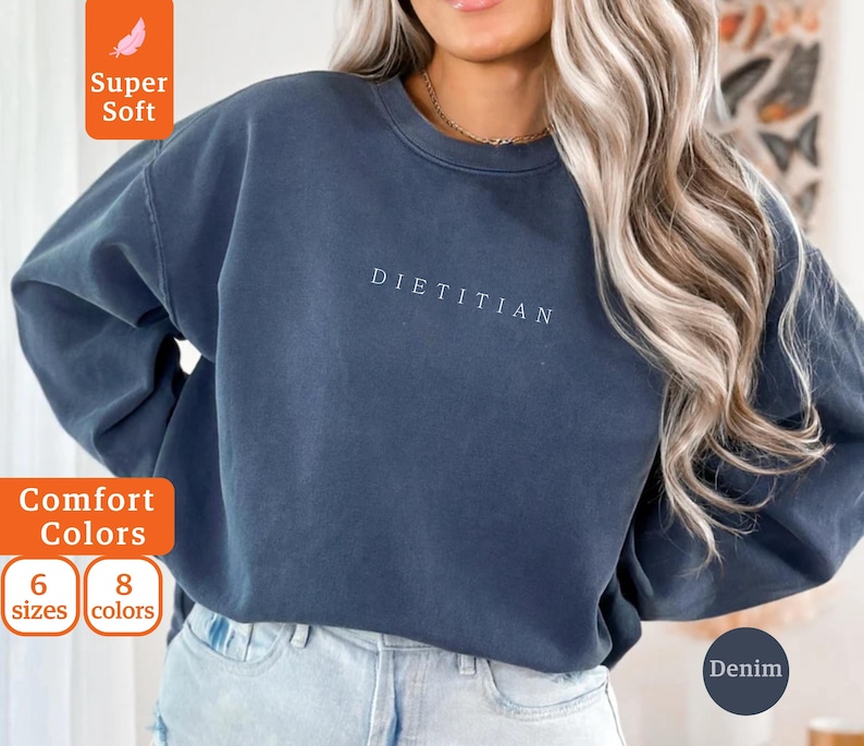 May include: A dark blue sweatshirt with the word "DIETITIAN" printed in white on the front. The sweatshirt is made of a soft, comfortable fabric and has a relaxed fit.