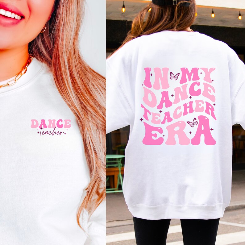 May include: White sweatshirt with pink text that reads "In My Dance Teacher Era" with butterfly graphics. The text is in a retro font style.