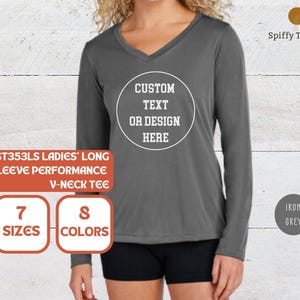 May include: An iron grey long-sleeve performance V-neck tee featuring a white circular graphic on the chest with the text CUSTOM TEXT OR DESIGN HERE. The shirt is displayed with text overlays indicating 7 sizes and 8 colors are available.