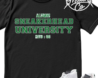 May include: A black short-sleeve t-shirt featuring the green text ALUMNI SNEAKERHEAD UNIVERSITY ESTD : OG and a white and green sneaker graphic. The top right corner displays a circular logo with the text Sneaker Match Co.