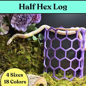 May include: A purple half hex log structure with a honeycomb pattern, featuring a light-colored snake with yellow bands resting on it. The image includes text that reads Half Hex Log, 4 Sizes, and 18 Colors, with purple flowers and green moss.