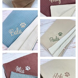 Op de afbeelding: Zes gepersonaliseerde honden dekens met verschillende namen geborduurd erop. De dekens zijn gemaakt van een zacht, pluche materiaal en hebben een omkeerbaar ontwerp. De namen op de dekens zijn Bella, Maya, Balu, Paula, Mia en Loki.