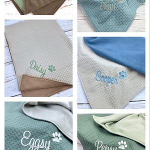 Op de afbeelding: Zes gepersonaliseerde honden dekens met verschillende geborduurde namen. De dekens zijn omkeerbaar met een zachte, pluche kant en een kant met een wafelstructuur. De namen op de dekens zijn Luna, Liv, Daisy, Cooper, Eggsy en Pepsy.