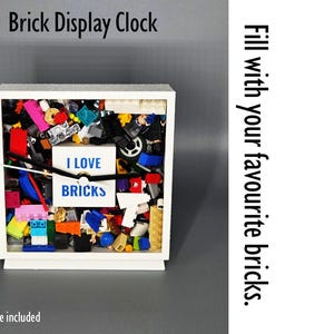 May include: White display clock filled with colorful toy bricks. The clock face reads "I LOVE BRICKS." The text "Brick Display Clock" is at the top, and "No bricks are included" is at the bottom. The side reads "Fill with your favourite bricks."