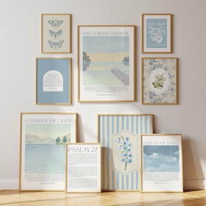 May include: A selection of framed art prints with gold frames. The prints display diverse designs, including butterflies, floral patterns, and inspirational quotes. The colour palette is soft, with blues, greens, and beige tones. The prints are arranged on a white wall.