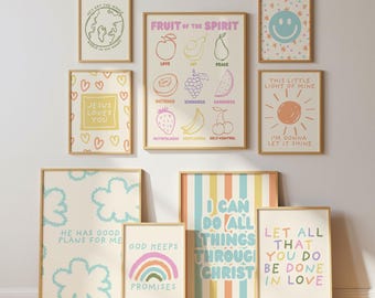 May include: A gallery wall arrangement of nine framed art prints featuring pastel-colored illustrations and text. Designs include a globe, a smiley face, a sun, a rainbow, clouds, and fruit icons with text such as Fruit of the Spirit and Jesus Loves You.