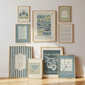 May include: A gallery wall set of nine framed art prints featuring botanical, animal, and script designs in muted blue, green, and cream tones. The collection includes text-based posters with religious themes, floral illustrations, and striped patterns.