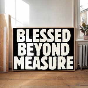 Könnte beinhalten: Ein schwarz-weißer gerahmter Druck mit dem Text "Blessed Beyond Measure" in großen, fetten, weißen Buchstaben.