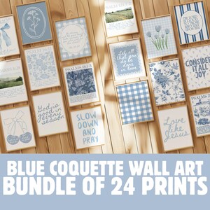 May include: A set of 24 framed wall art prints featuring blue and white designs, including floral motifs, bows, and inspirational quotes. The prints are displayed on a wooden surface, offering a coordinated look for home decor.