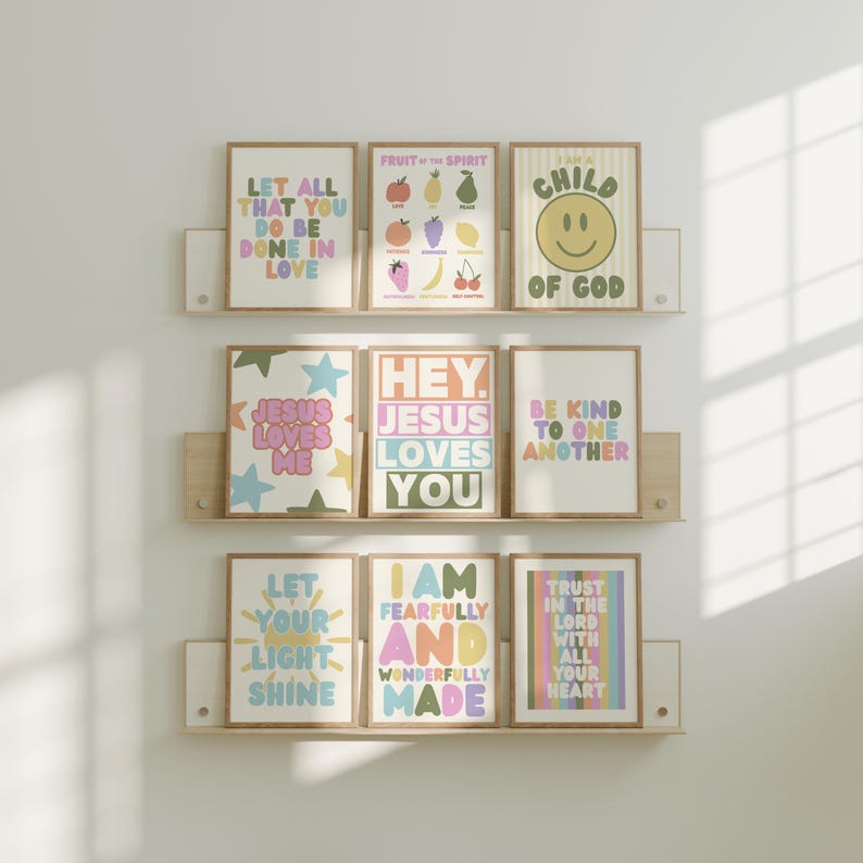 May include: Nine framed art prints with inspirational quotes and phrases in pastel colors. The prints are arranged on wooden shelves. The phrases include "Let all that you do be done in love" and "I am fearfully and wonderfully made."