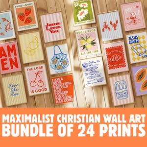 May include: A collection of 24 framed art prints with various designs, including fruit, fish, and religious phrases like "Jesus Loves You" and "God is Good." The prints are arranged on a wooden surface, creating a visually appealing display.