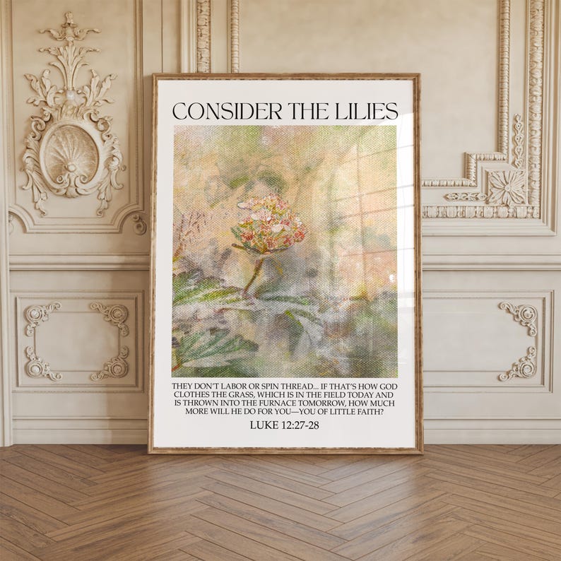 May include: Framed art print with the text "CONSIDER THE LILIES" at the top. The image features a floral design with a soft, textured background. Below the image is a quote from Luke 12:27-28.