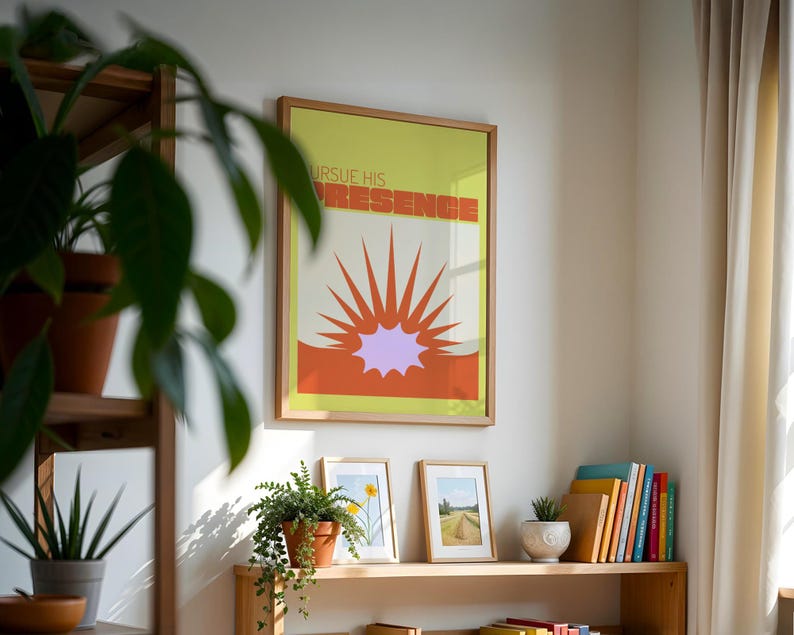 May include: A framed print with a yellow background and orange and purple sunburst design. The text "Pursue His Presence" is written in a retro font.