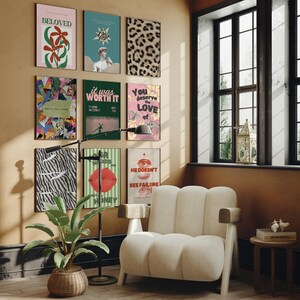 May include: A living room interior with a white armchair, a floor lamp, and a wall decorated with colorful posters. The posters feature various designs, including a zebra print, a red lip, and a quote about love.