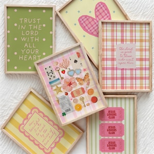 May include: A collection of framed art prints with various designs. One print features the text "TRUST IN THE LORD WITH ALL YOUR HEART" on a green background. Other prints have plaid, stripes, and decorative elements.