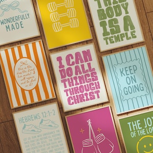 May include: A collection of framed art prints with inspirational quotes and graphics. Designs include dumbbells, boxing gloves, and phrases like "I can do all things through Christ" and "The joy of the Lord". The prints are in various colors.