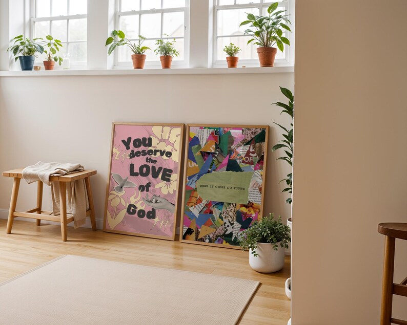 May include: Two framed prints on a wall. The print on the left is pink with the text "You deserve the LOVE of God". The print on the right is a collage of colorful paper scraps.