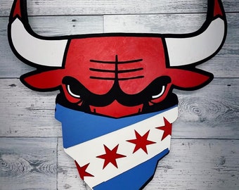 May include: A red and white bull's head with a blue and white bandana featuring three red stars. The bandana has the text "Chicago" on it.