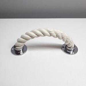 May include: A white cotton rope door handle with chrome end caps. The rope is twisted and the end caps are round.