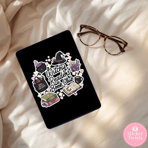 May include: A black tablet with a sticker featuring a witch hat, cauldron, potion bottle, and the text "Witchy Readers Book Club." The sticker also includes a stack of books, a coffee mug, and a tote bag. Tortoiseshell glasses rest nearby.