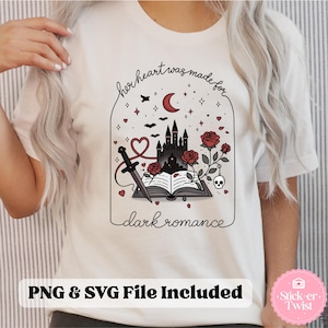 May include: White t-shirt with a graphic design featuring a castle, roses, a dagger, and the text "her heart was made for dark romance." The design includes a crescent moon, bats, and stars. The text "PNG & SVG File Included" is also present.