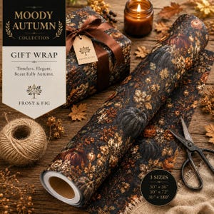 May include: A roll of gift wrap featuring a dark pattern of pumpkins, autumn leaves, and berries. The paper is displayed with a wrapped gift box, a ball of twine, and metal scissors. A tag on the box reads Moody Autumn Collection Frost & Fig.