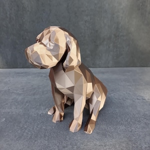 Könnte beinhalten: Eine geometrische Hundeskulptur in Braun- und Beigetönen. Der Hund sitzt, der Kopf leicht nach links gedreht. Die Skulptur hat ein facettiertes, polygonales Design, das ihr ein modernes, künstlerisches Aussehen verleiht. Der Hintergrund ist einfarbig grau.