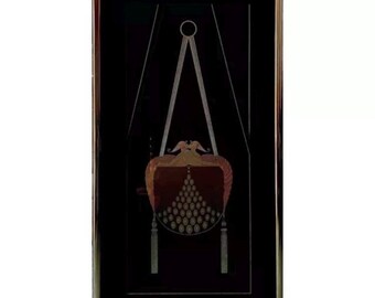 May include: A framed black and gold art print featuring a geometric design of a hanging purse with tassels. The purse is decorated with gold and red accents.