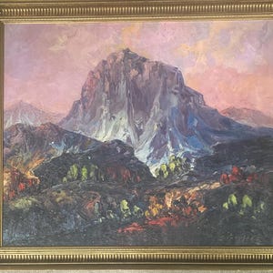 Pode incluir: Uma pintura de uma cordilheira com um grande pico rochoso no centro. O céu é de um rosa e laranja vibrantes, e as montanhas são de um roxo e verde escuros. A pintura é emoldurada em uma moldura dourada.