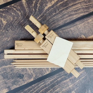 Könnte beinhalten: Holz-Leinwandspannrahmen mit zwei Holz-Spannzwingen. Die Rahmen sind 40 cm/16 Zoll lang und wurden in Polen hergestellt. Die Spannzwingen tragen die Gravur "Haftowany Zakatek".