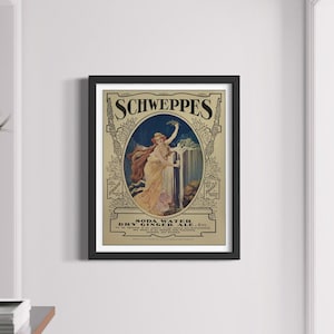 May include: Vintage Schweppes Dry Ginger Ale advertisement featuring a woman in a flowing white dress holding a glass of ginger ale. The advertisement is framed in black and set against a white wall.
