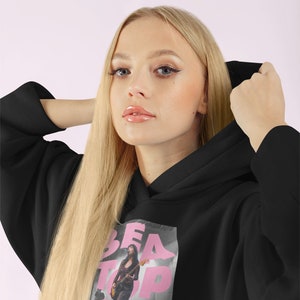 May include: Black hoodie with a pink graphic print of a woman playing a guitar with the text "BEATPIA" on it.