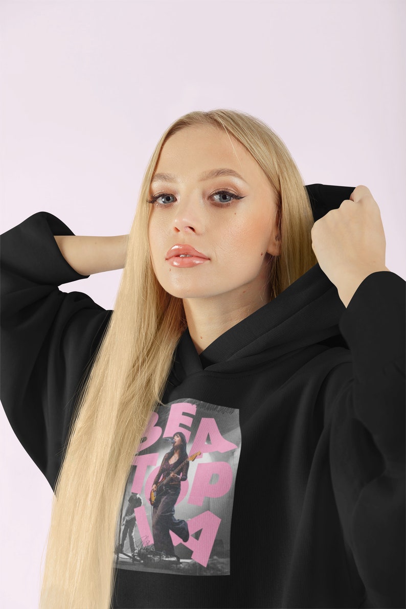 May include: Black hoodie with a pink graphic print of a woman playing a guitar with the text "BEATPIA" on it.