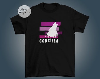 May include: Black t-shirt with a white silhouette of Godzilla roaring against a pink and purple striped background. The text "GODZILLA" is printed below the silhouette.