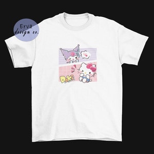 May include: White t-shirt with a graphic print of two cartoon characters. The characters are a purple cat with a pink bow and a white cat with a pink bow. The text "Doki Doki" is printed below the characters.
