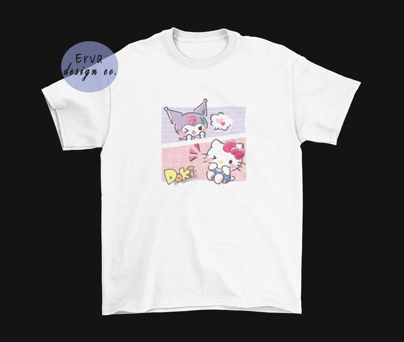 May include: White t-shirt with a graphic print of two cartoon characters. The characters are a purple cat with a pink bow and a white cat with a pink bow. The text "Doki Doki" is printed below the characters.