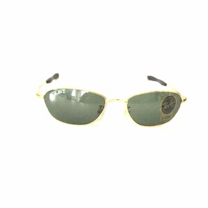 May include: Gold-framed sunglasses with green lenses. The sunglasses have a Ray-Ban logo on the right lens.