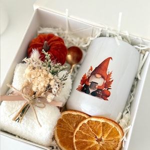 May include: A white gift box containing a white mug with a gnome graphic, a small red velvet pumpkin, a gold-toned spoon, a white fuzzy cloth, a dried floral bouquet tied with twine, and two dried orange slices, with the text Set 6 visible.