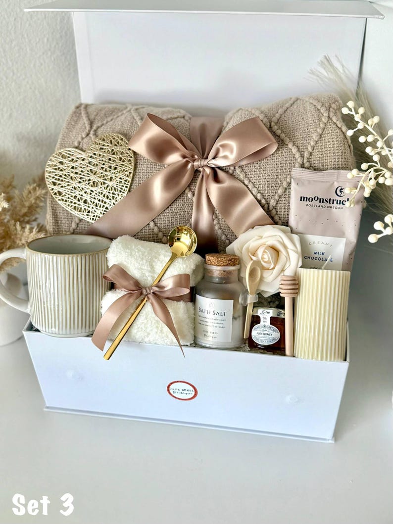 Puede incluir: Caja de regalo con art&iacute;culos de cuidado personal. Incluye una manta beige, una taza, sales de ba&ntilde;o, una toalla, miel, una vela y un coraz&oacute;n decorativo. La caja est&aacute; atada con una cinta de raso.