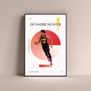 May include: A basketball poster featuring De'Andre Hunter, a basketball player for the Atlanta Hawks. The poster is white with red, yellow, and black accents. The poster includes the text "#12", "De'Andre Hunter", "Hawks", "12", "2019/Round 1/Pick 4", "Atlanta Hawks", and "SF".