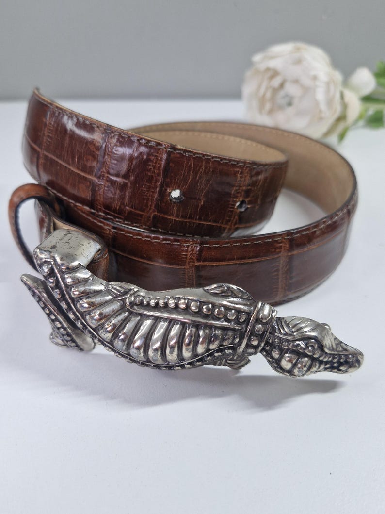 May include: A set of three ceramic vases in varying heights and shapes. The vases are glazed in a matte, earthy green color. The tallest vase is approximately 10 inches high.