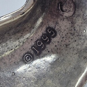 May include: A white ceramic mug with a black handle and the text "But First, Coffee" in a black, bold font. The mug is on a white surface. The mug is approximately 4 inches tall.