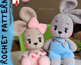 May include: Two crocheted gray bunny plushies, one wearing a pink skirt and a pink bow, the other wearing blue overalls. The plushies are sitting on a wooden table. The image includes the text "@olya.usolya".